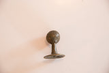 Angled view of the bronze Tritcraf collectible with textured sphere and signed base.