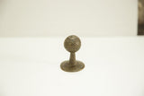 Textured bronze Tritcraf sphere on slender stand, displaying vintage time-softened tones.