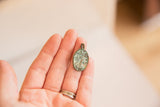 Intricate Tree of Life design on vintage bronze pendant with green patina.