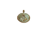 A round, vintage bronze African pendant with a raised crab design and a rich, green patina.