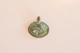 A collectible bronze crab pendant with a rich, aged green patina.