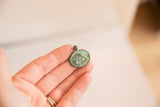 Vintage African bronze crab pendant held in hand to show scale and texture.