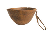 Hand-carved vintage African bowl, brown wood, with visible cracks, repairs, and leather strap.
