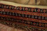 Textured vintage Persian rug fragment pillow, with traditional red, navy, and cream motifs.