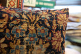 Textured close-up of Kerman fragment pillow, displaying worn navy, gold, red floral design.