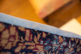 Antique Kerman fragment pillow edge, woven blue, maroon, and tan pattern with light blue binding.