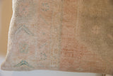Hand-knotted vintage Oushak rug fragment pillow texture with faded peach and teal patterns.