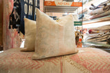 Vintage hand-knotted Oushak rug fragment pillow with subtle beige, pink, and blue geometric motifs.