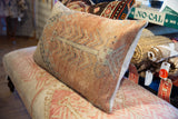 Faded hand-knotted texture and soft terracotta pattern on a vintage Oushak pillow.