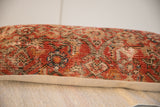 Hand-knotted Malayer rug fragment pillow, displaying time-softened red, cream, and blue tones.