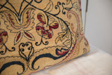 Textured antique Kerman pillow showcasing curvilinear red and dark blue floral motifs.