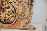 Textured side of antique Persian Kerman rug fragment pillow, revealing foundation and bold floral motifs.