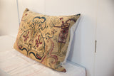 Antique Persian Kerman rug fragment pillow with time-softened tones and mythical motifs.