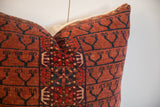 Hand-knotted vintage rug pillow showing woven texture and bold navy geometric Turkmen motifs.