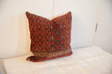 Intricate geometric border on lower corner of vintage Turkmen pillow, showing red and gold details.