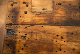 Reclaimed wood coffee table top with rustic texture, dark stains, and varied holes.