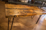 Reclaimed coffee table's thick, distressed wood edge, showing rustic texture and bolt.
