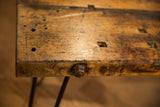 Rustic reclaimed wood coffee table edge with distressed texture and metal bolt detail.