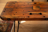 Side profile of reclaimed wood coffee table, showing thick timber and black hairpin legs.