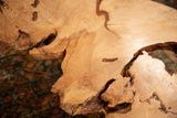 Expressive live edge wood tabletop detail, showcasing natural grain and organic shape.