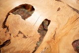 Expressive live edge wood coffee table surface featuring natural grain, cracks, and organic voids.