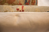 Detail of antique Persian Sultanabad rug fragment pillow pile and woven beige linen backing.