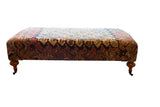 Antique Persian Rug Ottoman Coffee Table with harmonious Khorassan Doroksh patterns on carved wooden legs.