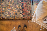 Ottoman's antique Persian Khorassan rug top, unique layout with geometric patterns in beige, red, blue.