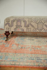 Light gray, purple geometric Oushak pattern on Vintage Turkish Rug Ottoman with mahogany leg and brass caster.