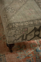 Curved mahogany leg with brass caster of the vintage rug ottoman.
