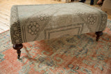 Textured vintage Oushak fragment, geometric pattern, light gray tones, mahogany leg.