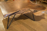 Natural textured live edge of rich walnut wood with a black metal leg.