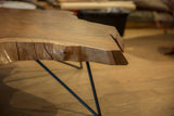 Live edge walnut tabletop with natural wood grain, subtle cracks, and organic texture.