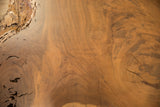 Textured live edge walnut with rich wood grain and natural surface cracks.