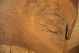 Natural live edge walnut wood grain with prominent rings and visible cracks.