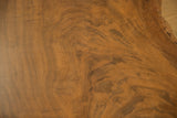 Close-up of the live edge walnut coffee table's rich, swirling grain with natural cracks.
