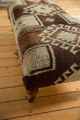 Textured brown and ivory geometric pattern on vintage Oushak rug fragment ottoman.