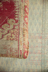 Time-softened raspberry, saffron, and ivory geometric patterns on an antique Anatolian rug edge.