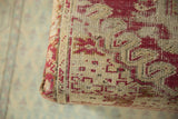 Textured antique Anatolian rug fragment with faded raspberry red and ivory geometric motifs.