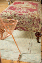 Curved mahogany finished wooden leg with brass caster of the antique rug ottoman.