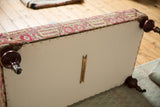 Rug ottoman table underside featuring cotton canvas, copper studs, and mahogany legs with casters.