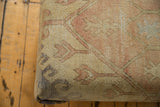 Upholstery corner of vintage Oushak rug fragment, pae yellow, pink, muted blue, and a dye spot.