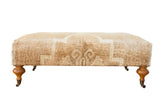 Vintage Oushak ottoman table, cream and tan Oushak pattern, carved wooden legs.
