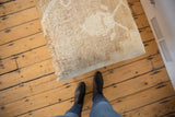 Soft cream and light brown vintage Oushak rug fragment, abstract pattern.