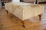 Hand-sewn corner detail of vintage Oushak rug ottoman, soft cream and gold pile.