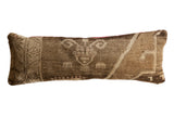 Distressed vintage Turkish Oushak rug fragment lumbar pillow with muted natural tones.