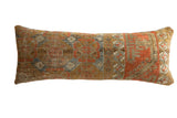 Antique Belouch fragment lumbar pillow with distressed geometric patterns in warm earth tones.