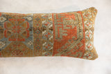 Aged texture and geometric patterns in rust, gold, and blue on the antique Belouch pillow.