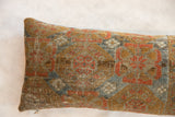 Detailed view of antique Belouch fragment pillow's textured surface and geometric pattern.