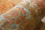 Aged hand-knotted pile of a rolled antique Belouch fragment, showcasing tribal patterns.